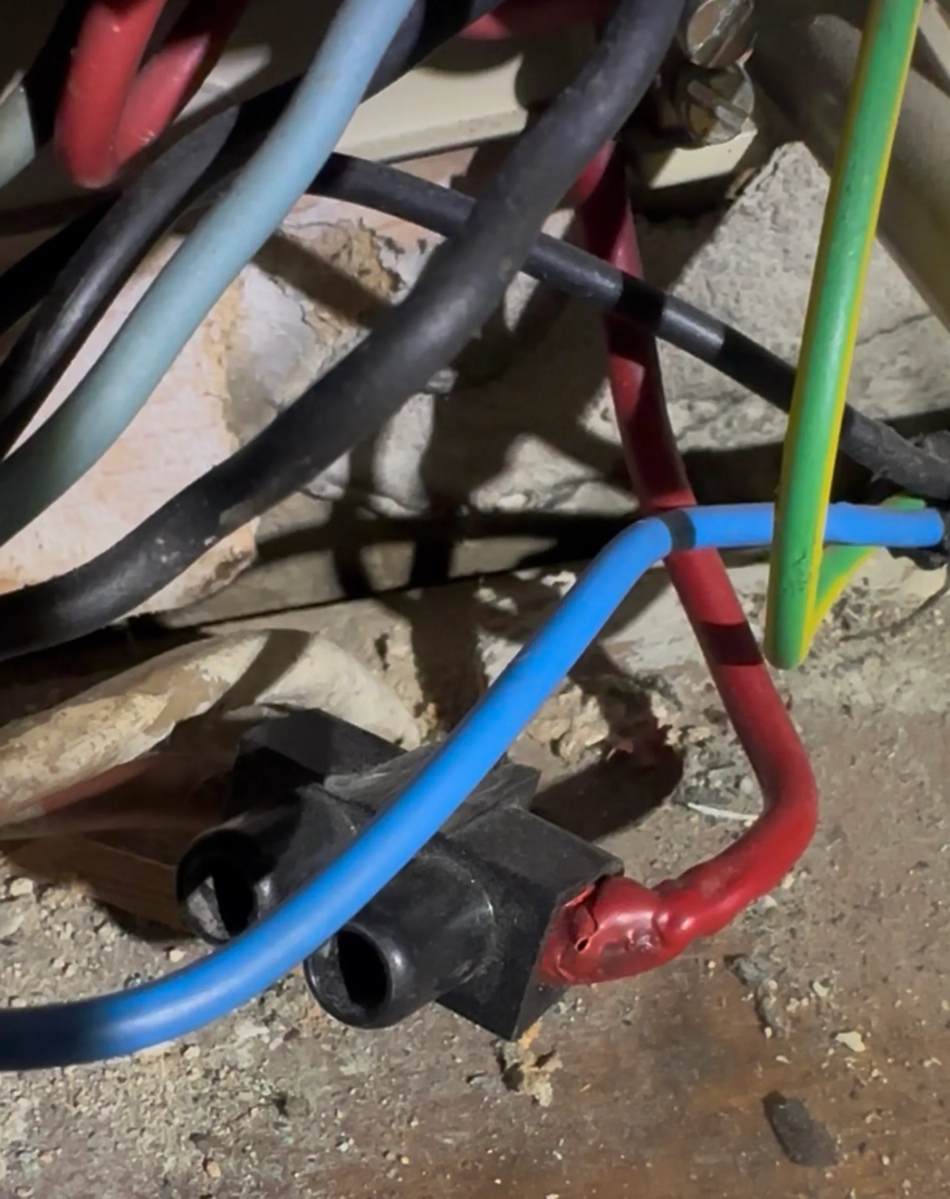Câbles raccordés sous un tableau électrique lors d'une recherche de panne